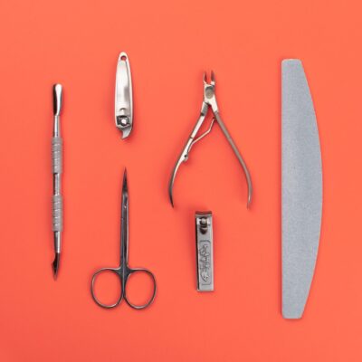 Equipment for cut manicure on coral background. Metal instruments for manicure. Nails salon and spa Flat lay Equipment for cut manicure on coral background. Metal instruments for manicure. Nails salon and spa Flat lay.